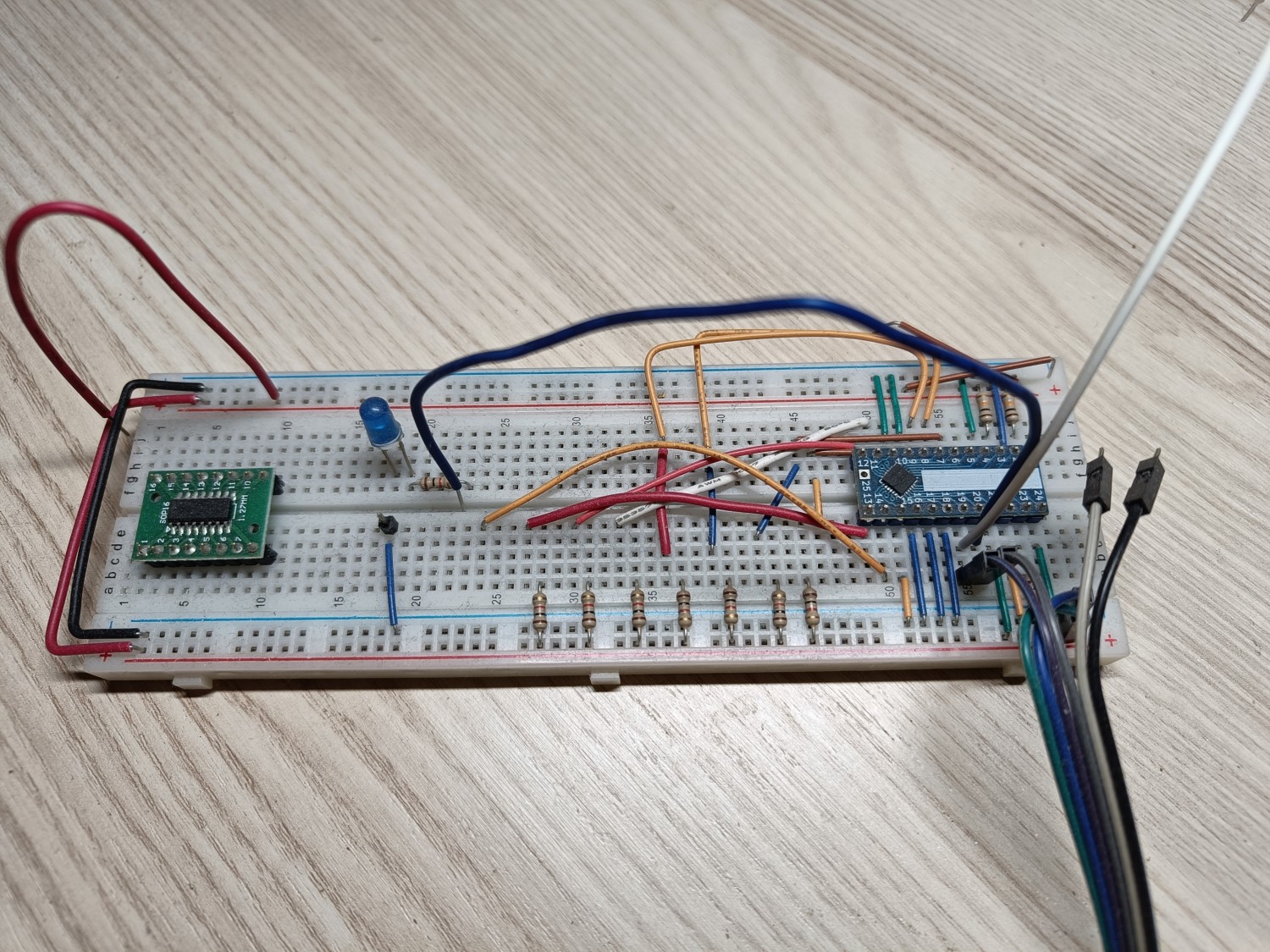 Photo of a breadboard with 2 chips, 1 LED and a whole lot of random cables